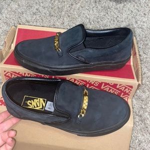 Black vans with gold pendant across it